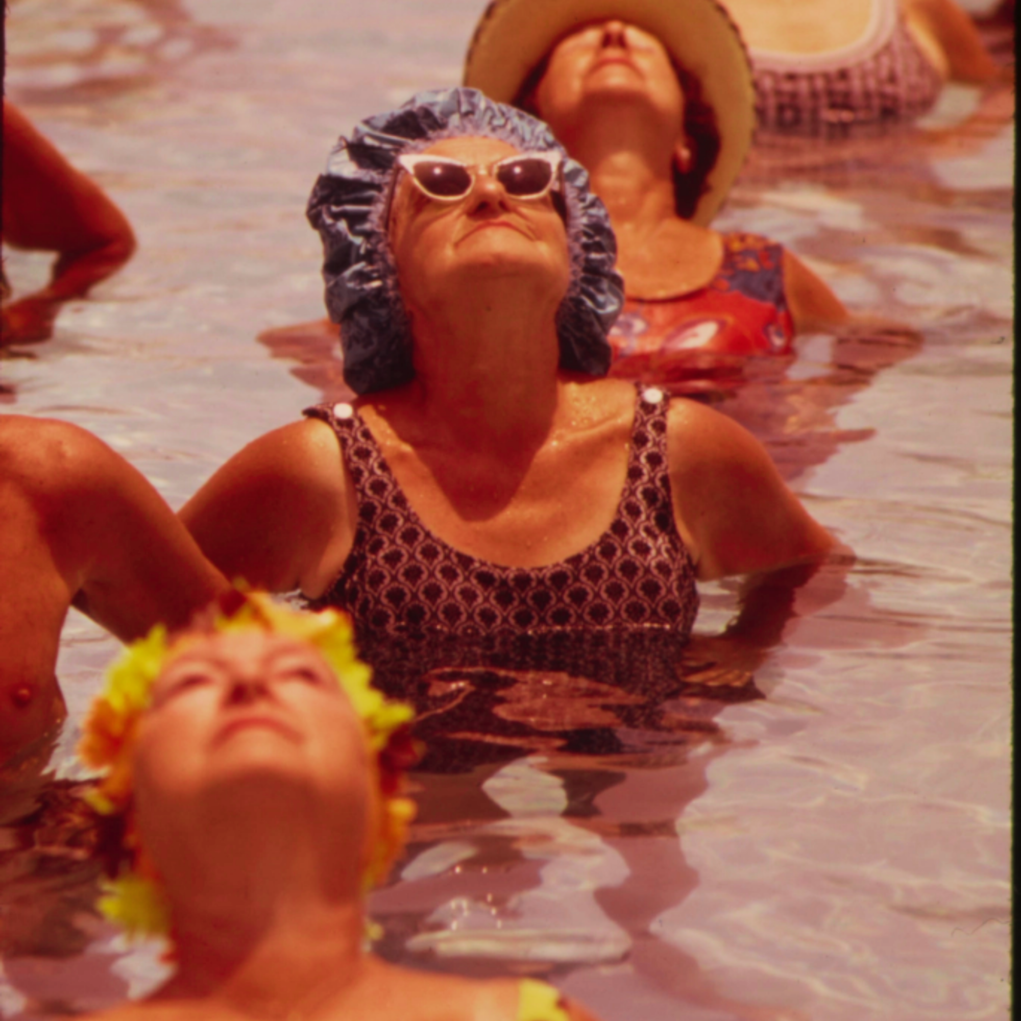 women standing up in a pool looking up into the sky