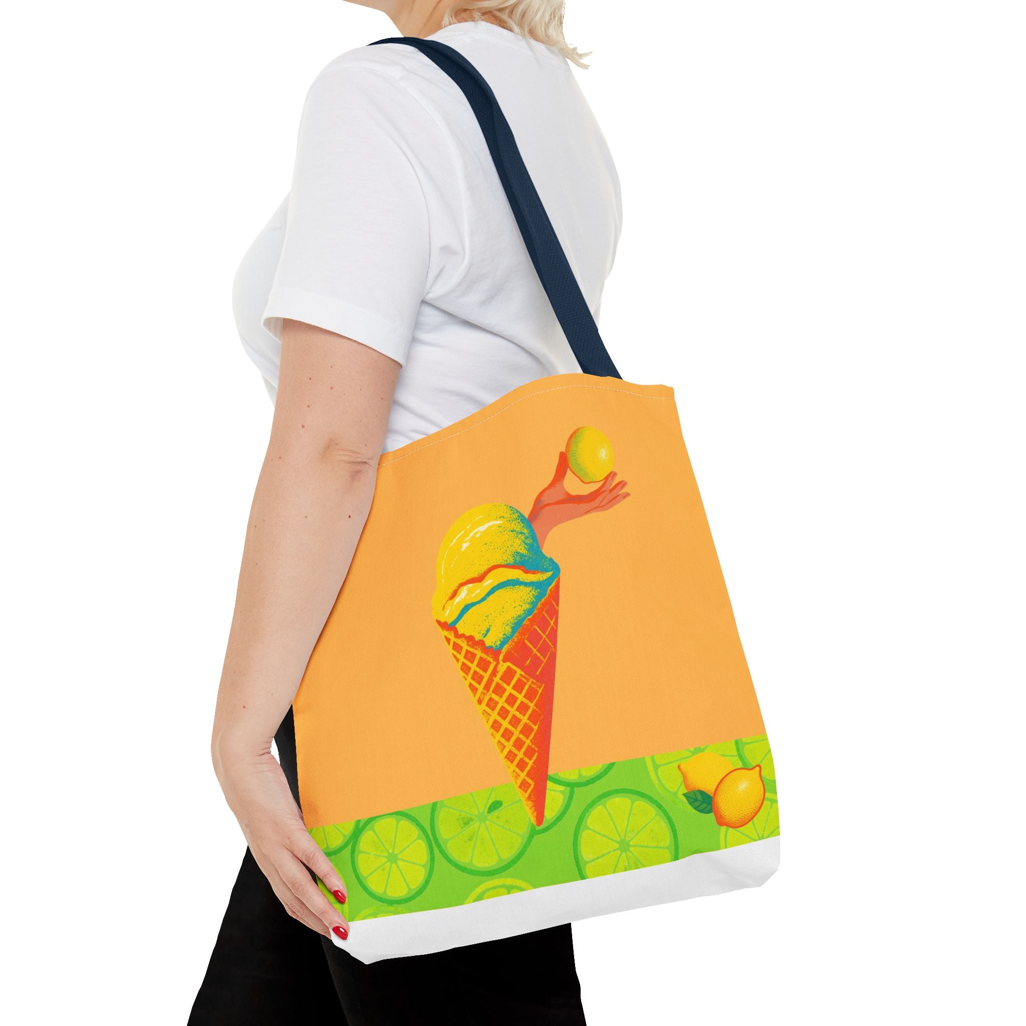 Person holding a tote bag with a colorful design of an ice cream cone and lemons on a white background