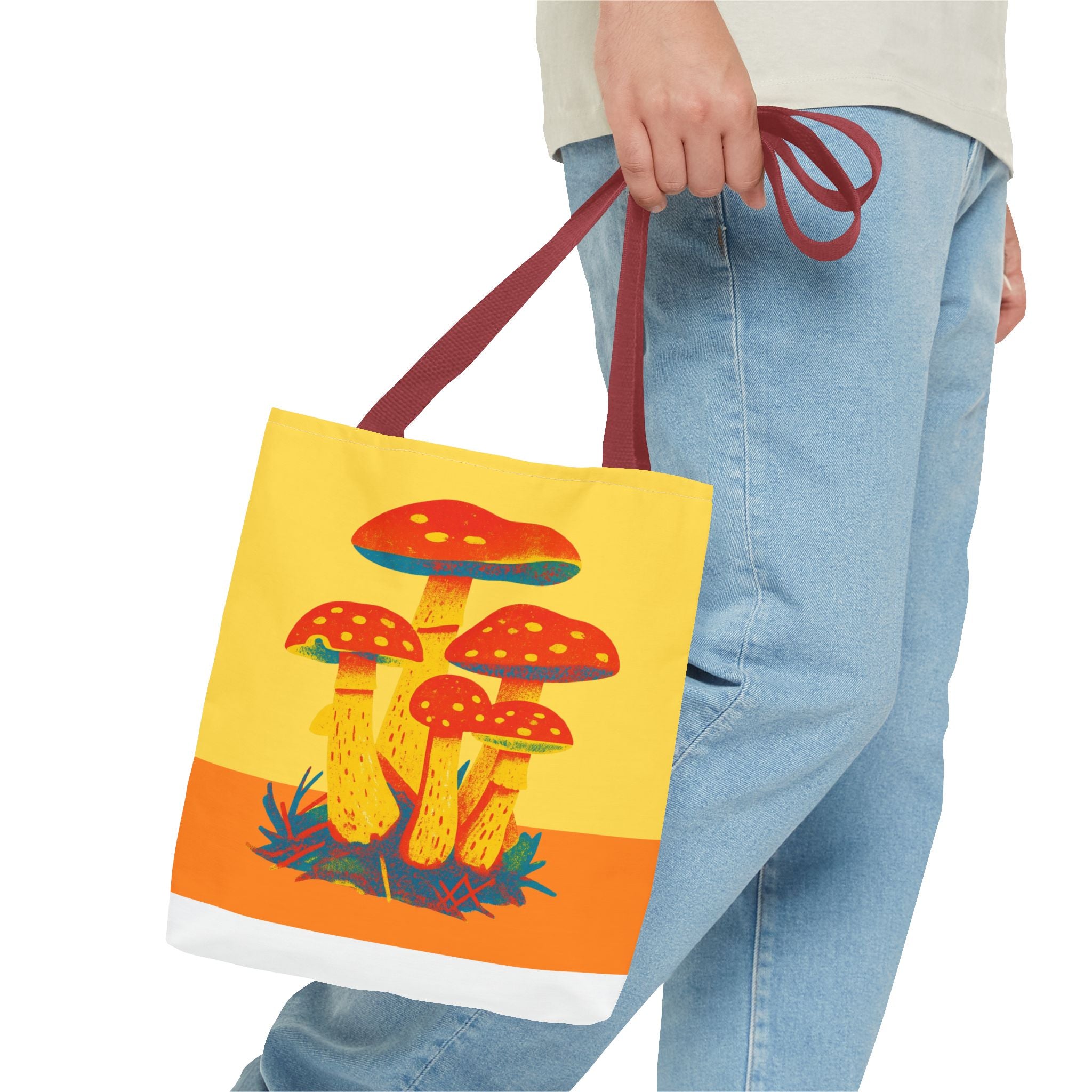 Tote bag with mushroom design held by a person wearing jeans