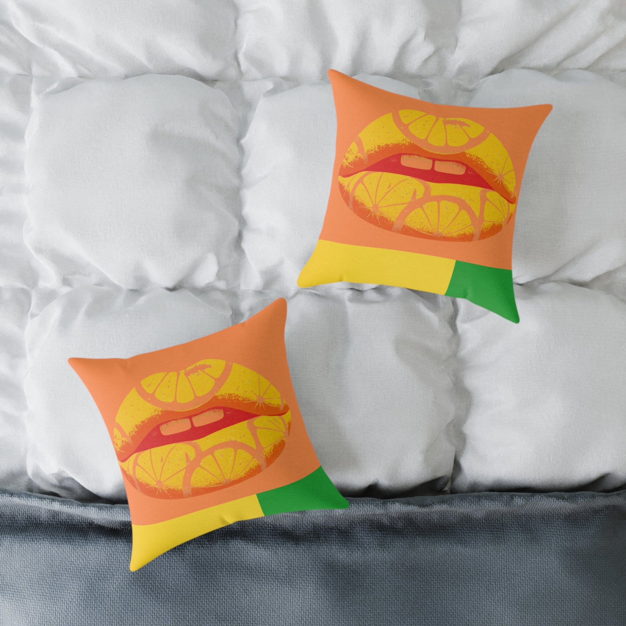 Two decorative pillows with a colorful lips design on a bed with white pillows and gray bedding.