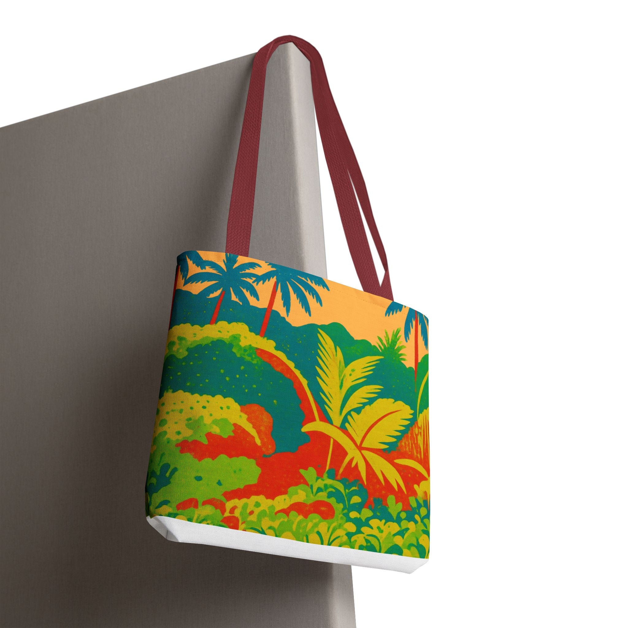 Tote bag with a colorful tropical design inspired by St Joseph in Barbados hanging on a Grey surface.