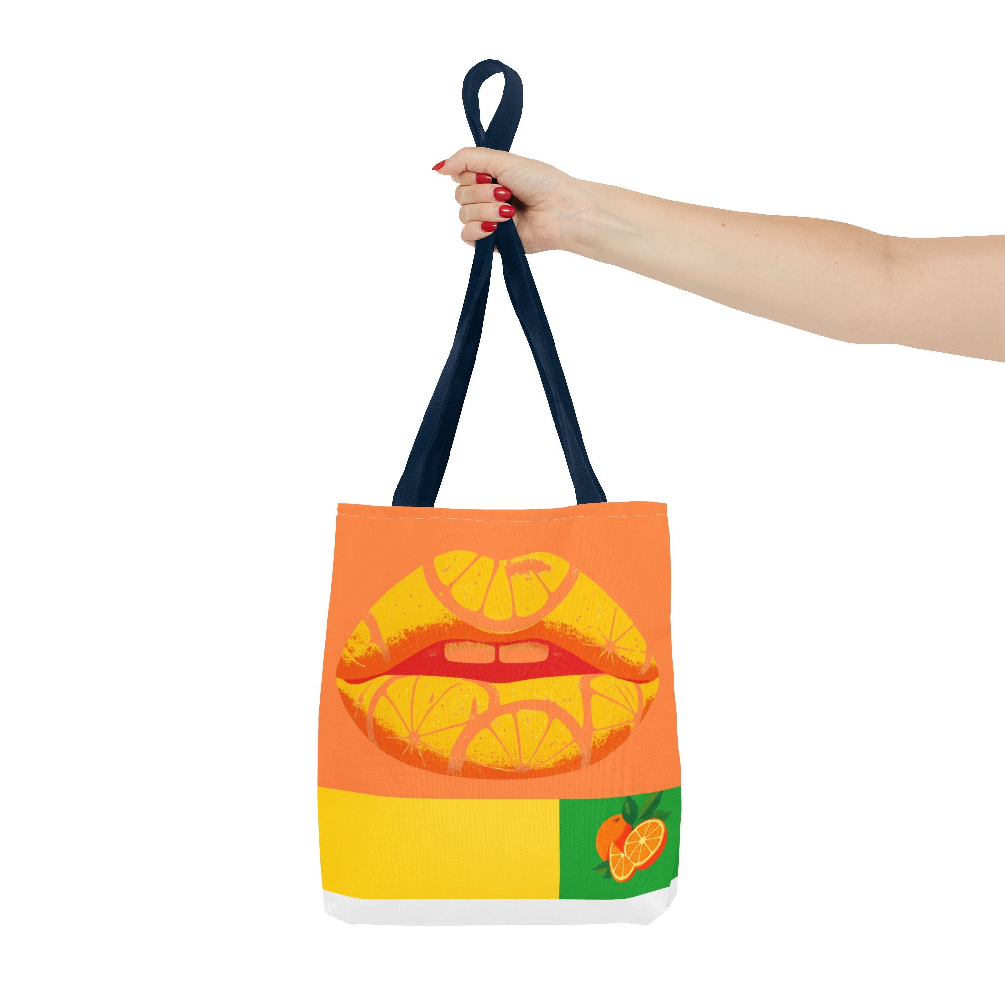 Tote bag with orange and yellow citrus lips design held by a hand on a white background