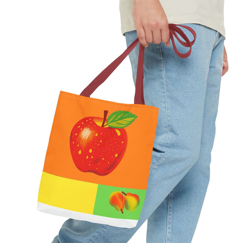 Tote bag with an apple design held by a person wearing jeans on a white background
