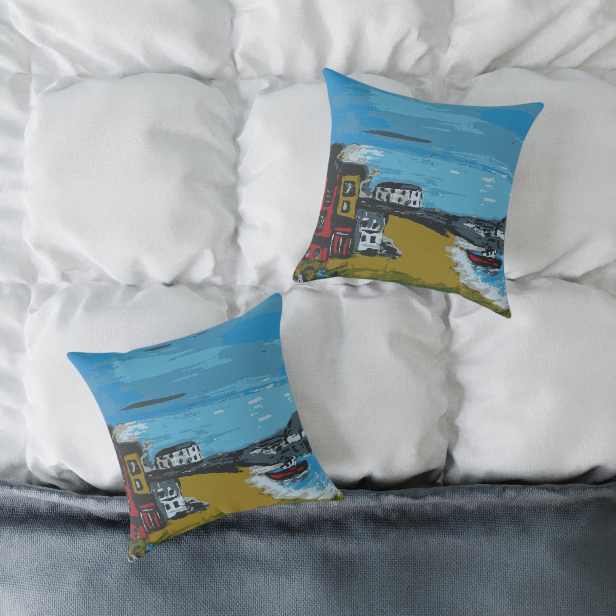 Two decorative pillows with artistic designs on a bed