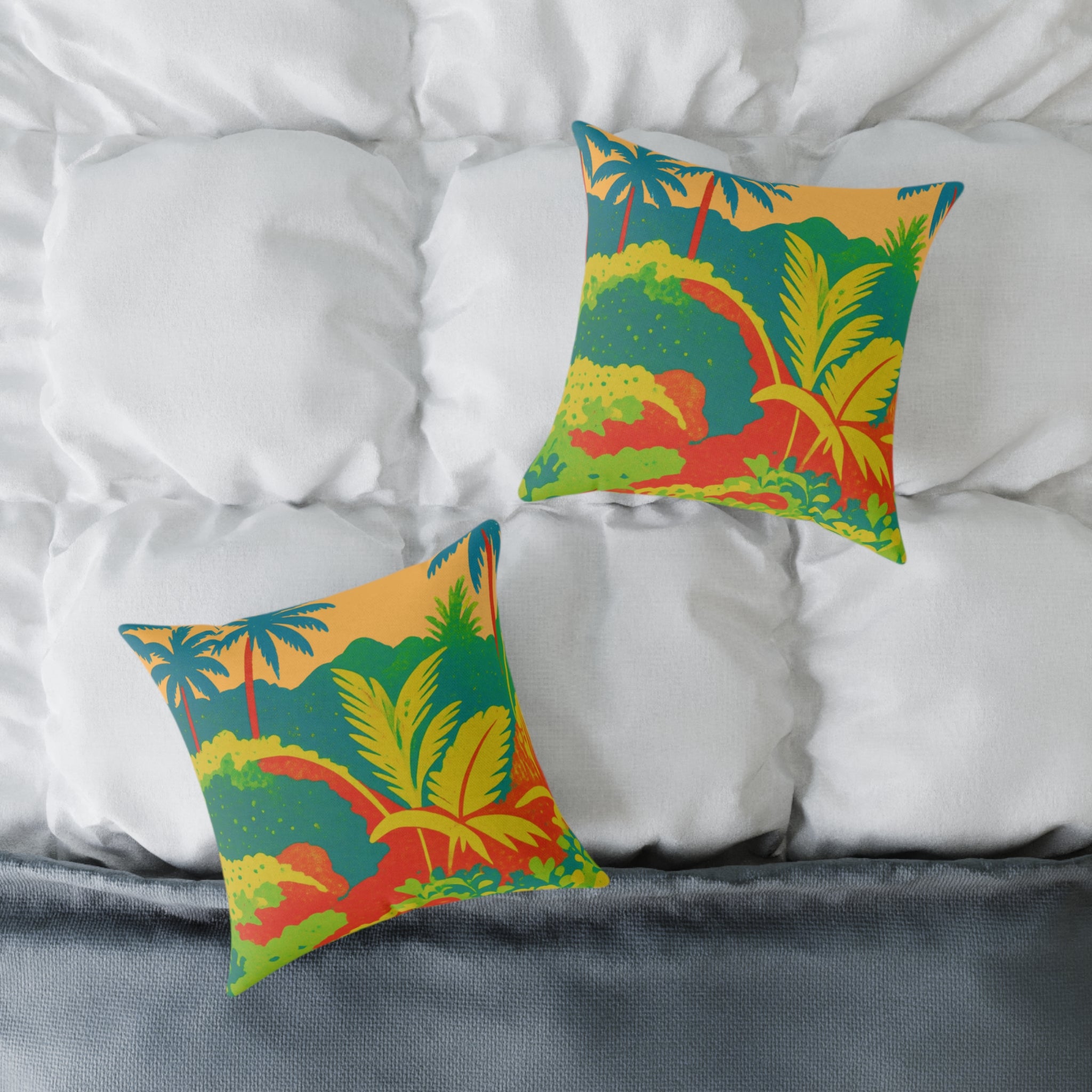 Two colorful pillows with a tropical design on a bed with white pillows and gray bedding.