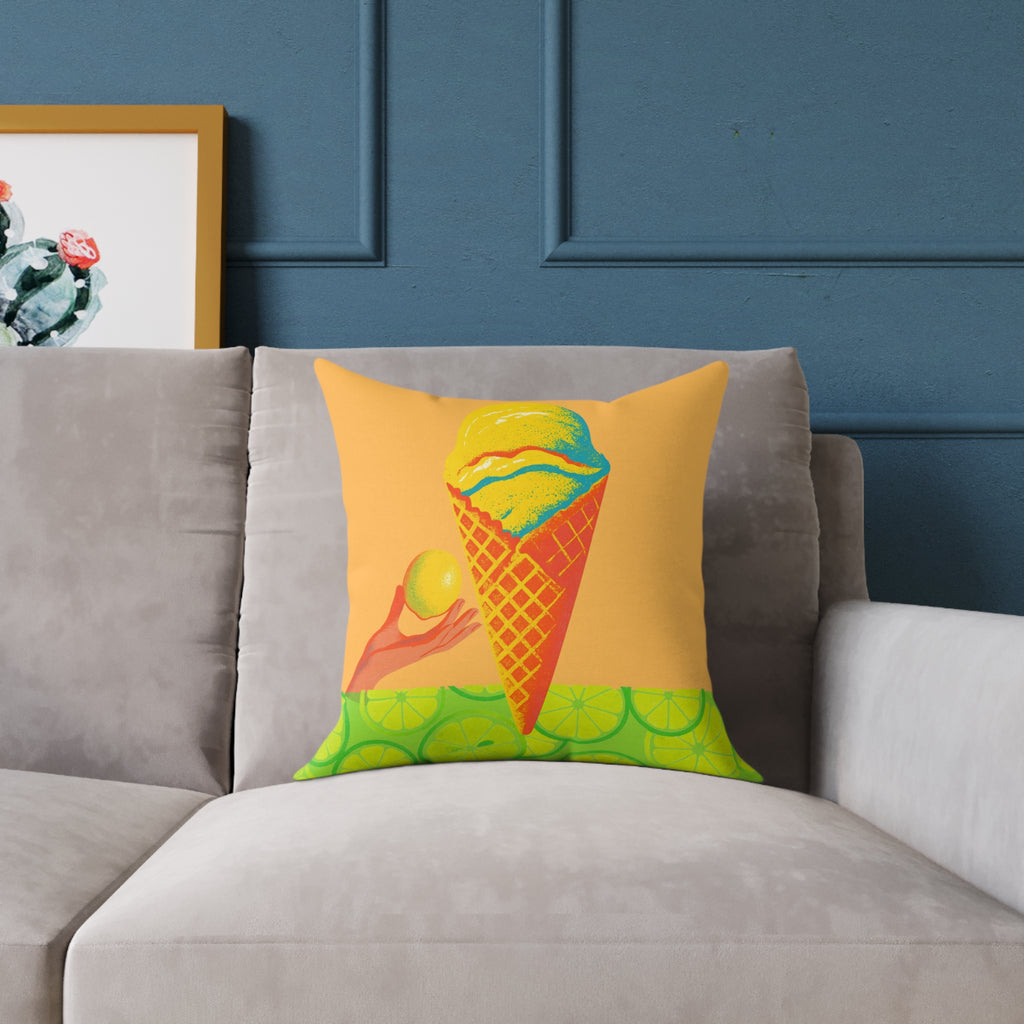 Decorative pillow with ice cream cone design on a gray sofa against a blue wall.