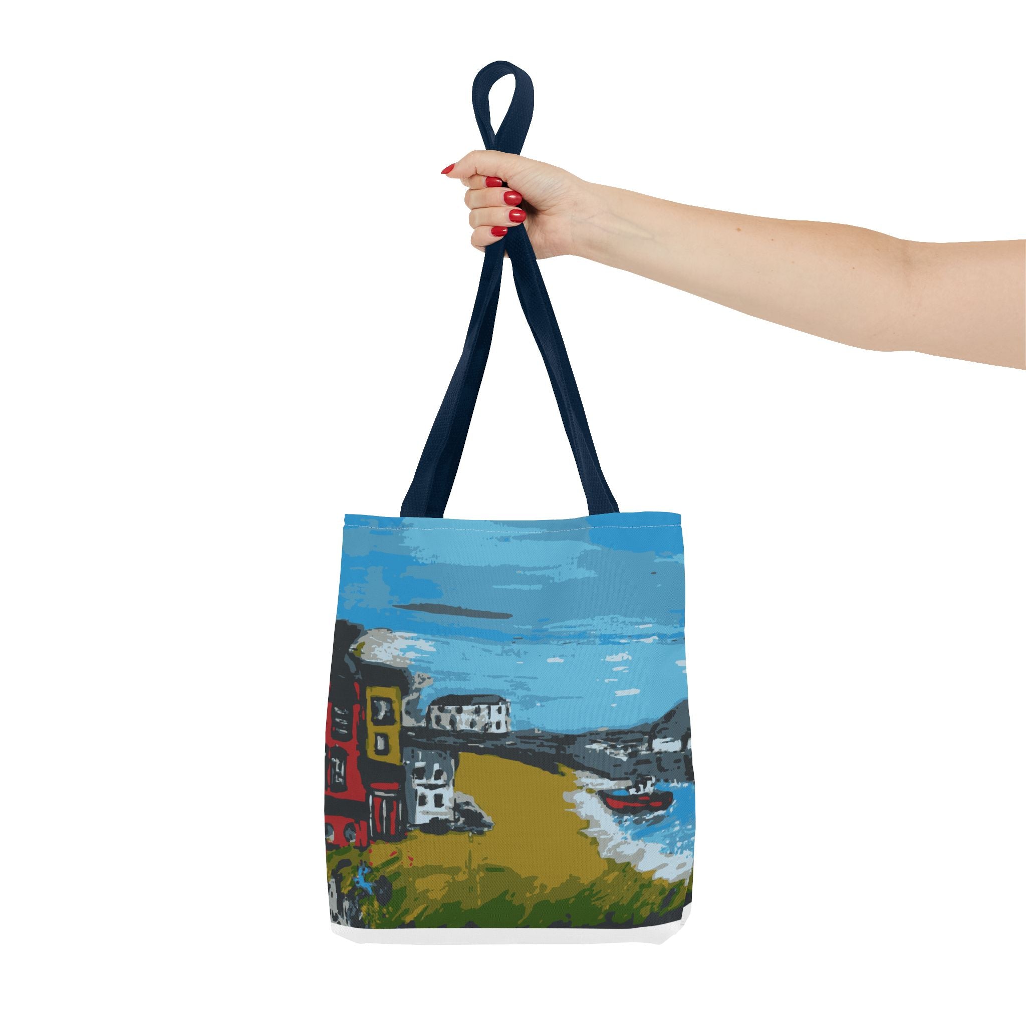 Woman's hand holding a Tote bag with a scenic design of  Viking Bay in Broadstairs, Kent showing houses and boats on a white background 