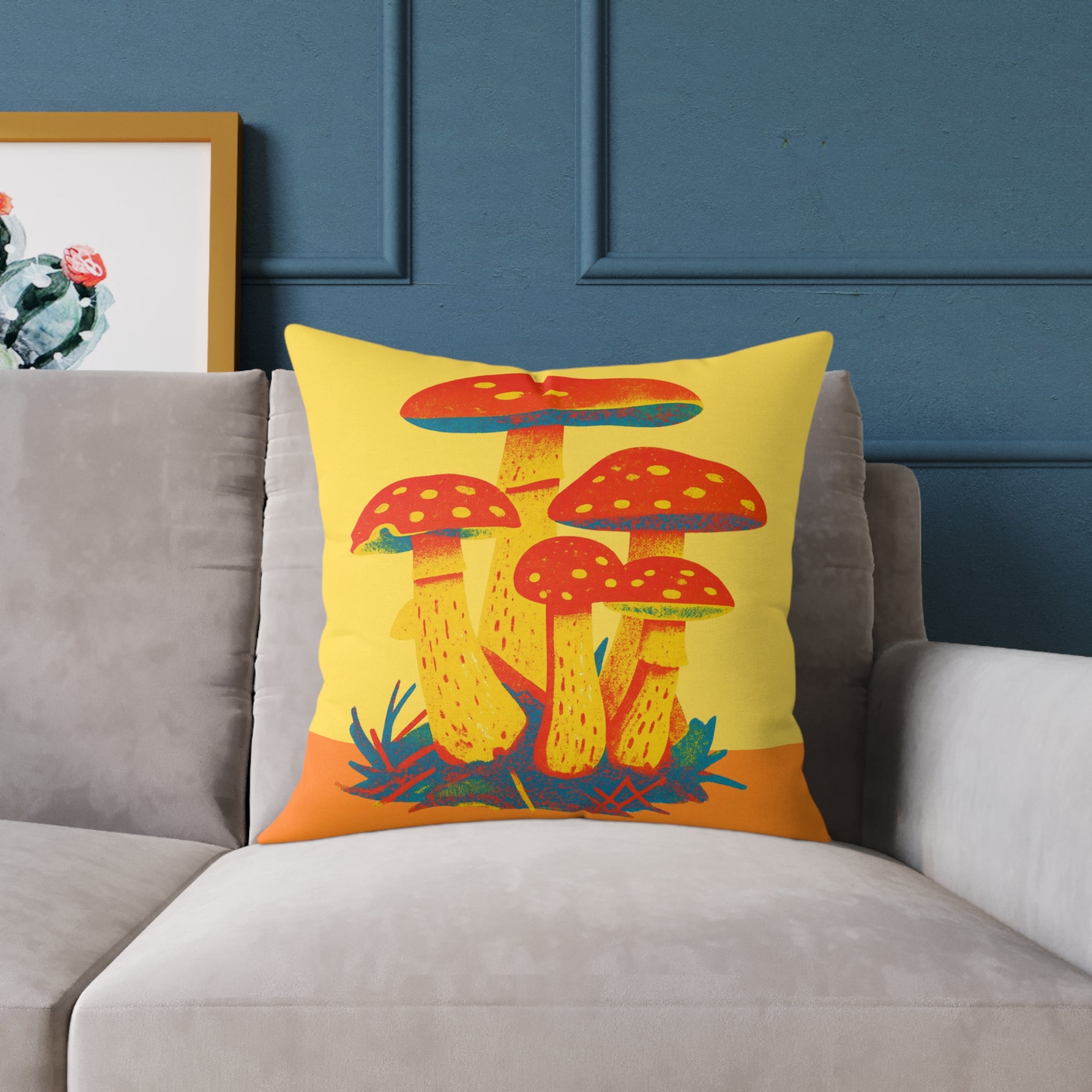 Colorful mushroom-patterned pillow on a gray sofa against a blue wall.