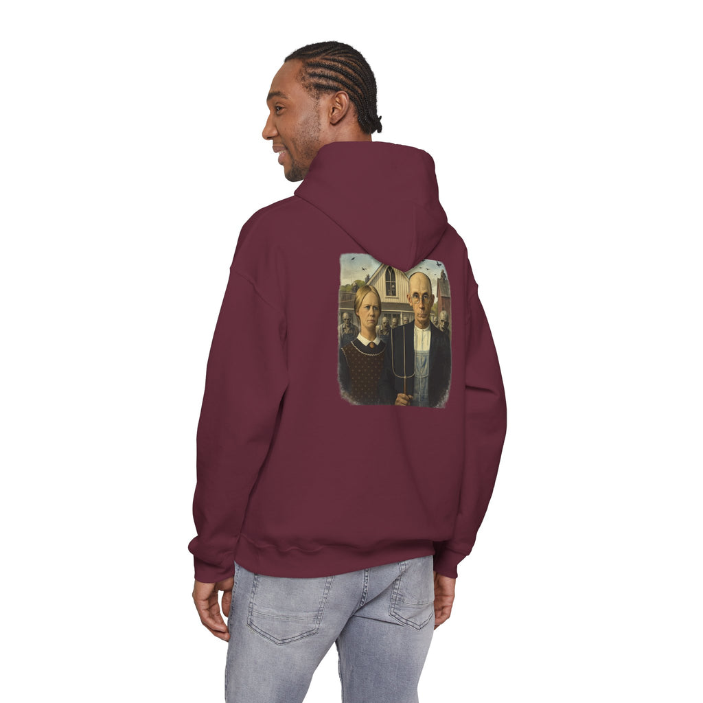 man wearing maroon  hoodie with a graphic of a  reimagined American Gothic by Grant Wood on the back, displayed on a white background.