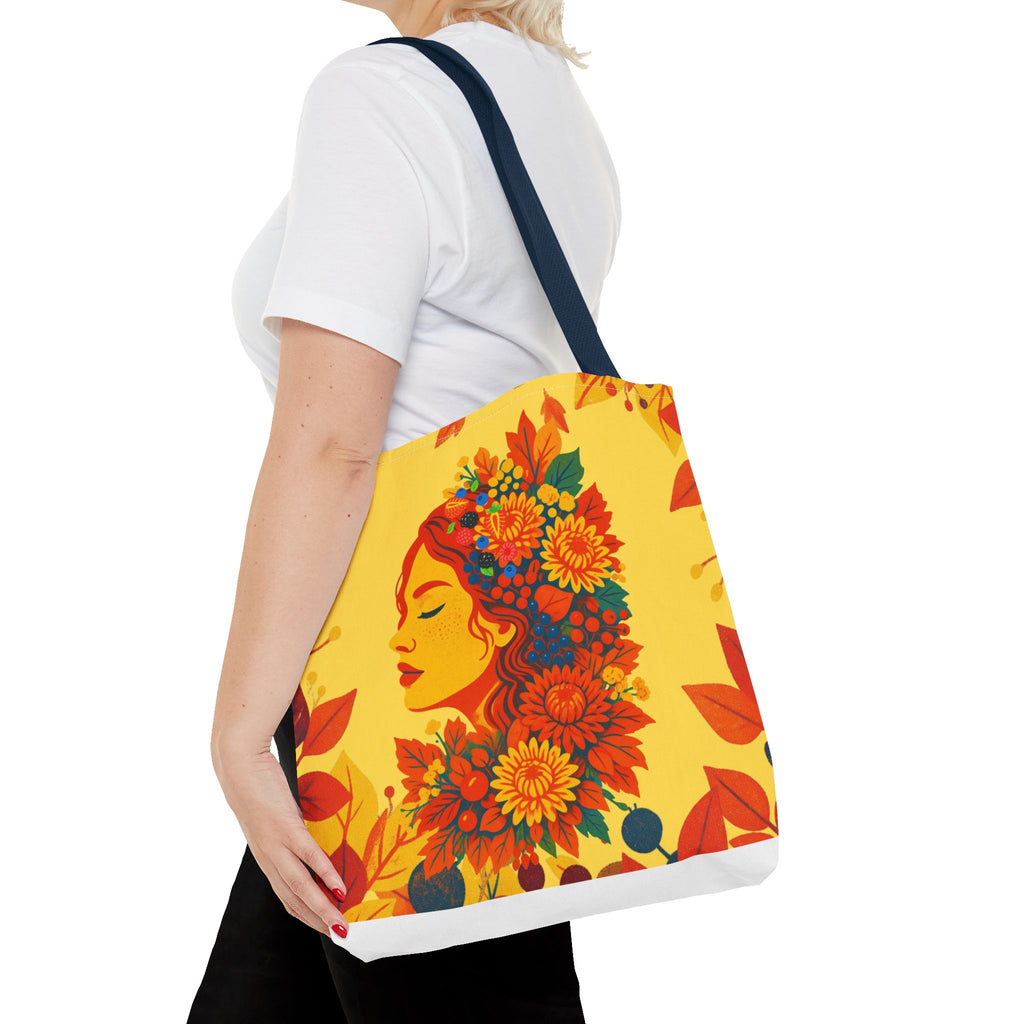 Person holding a tote bag with a colorful floral face design on a white background