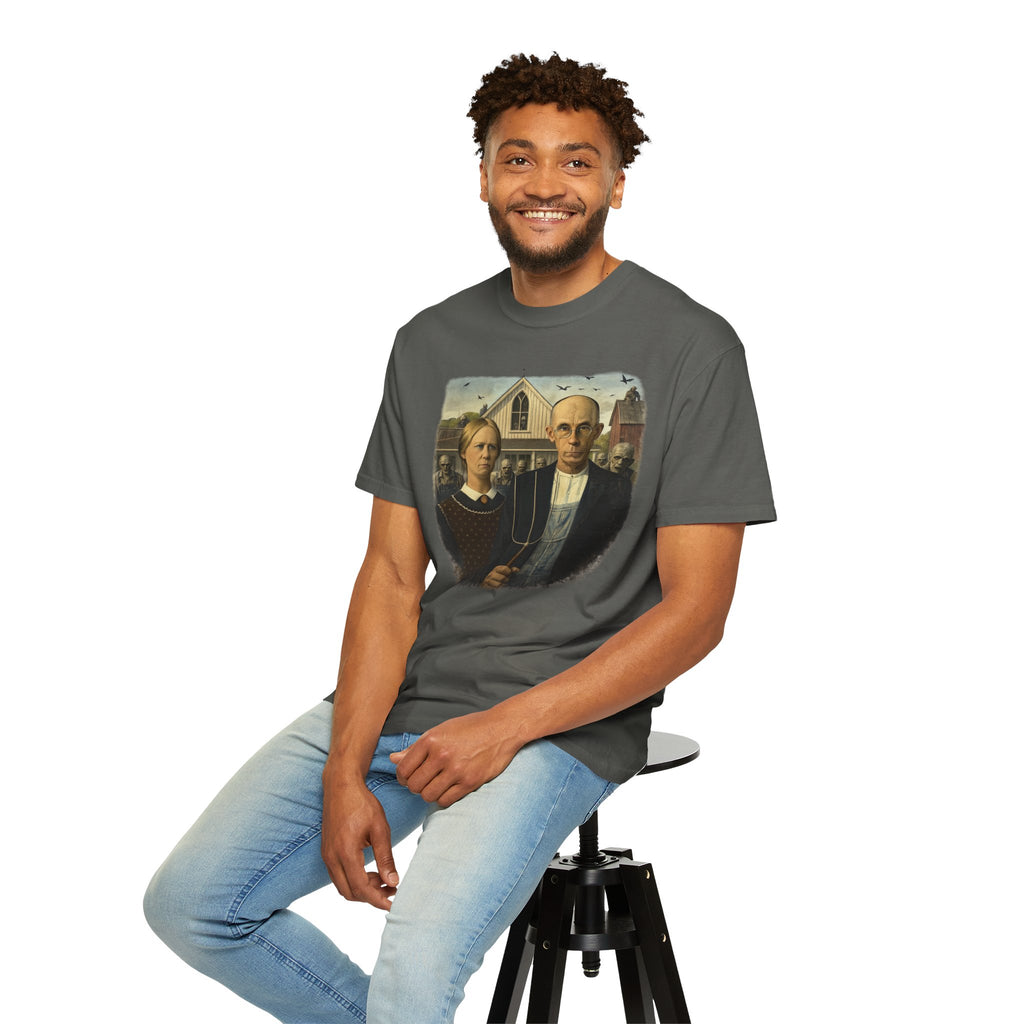 Man sitting down wearing gray t-shirt with reimagined image of zombies in American Gothic by Grant Wood on a white background
