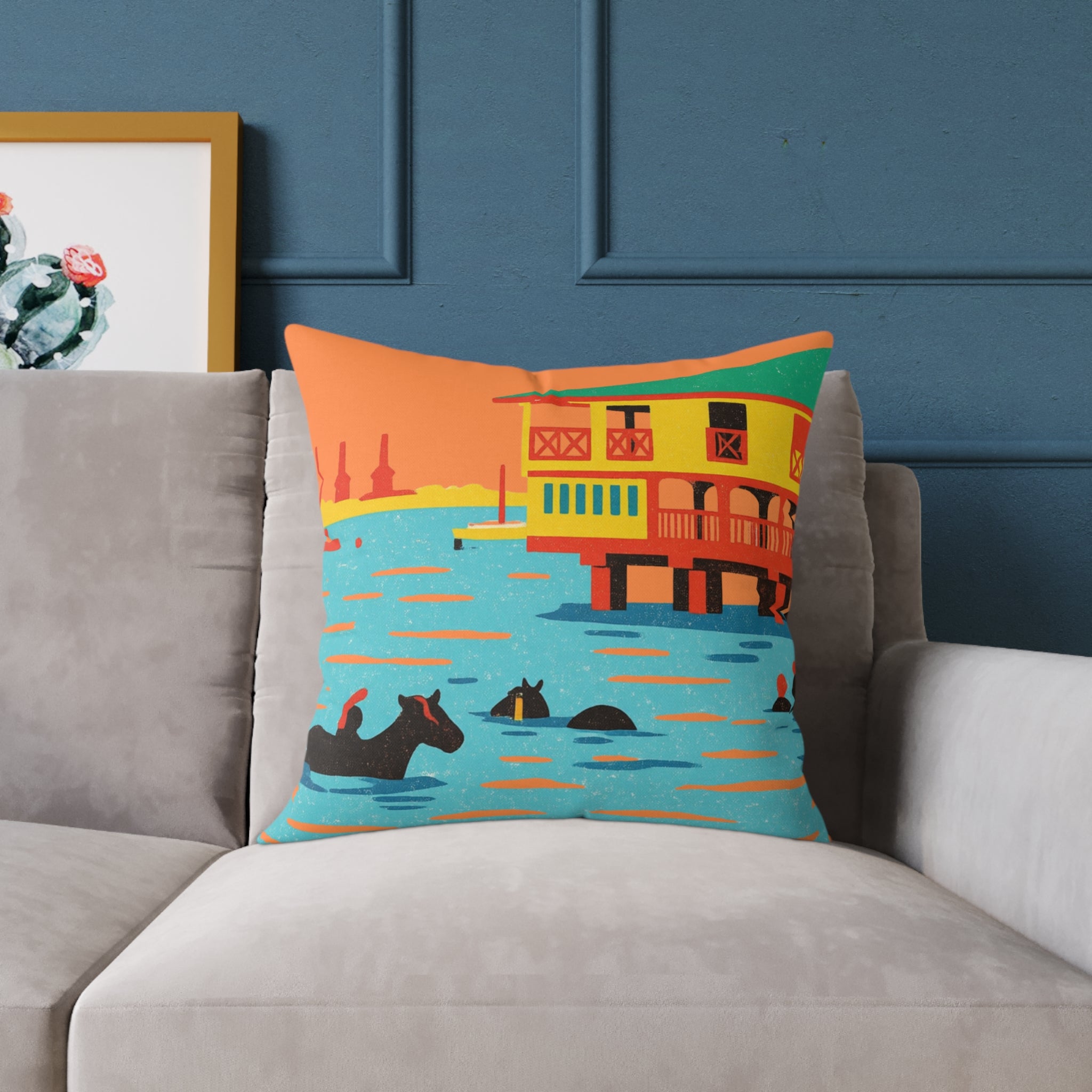 Decorative pillow with a colorful houseboat design on a gray sofa against a blue wall.