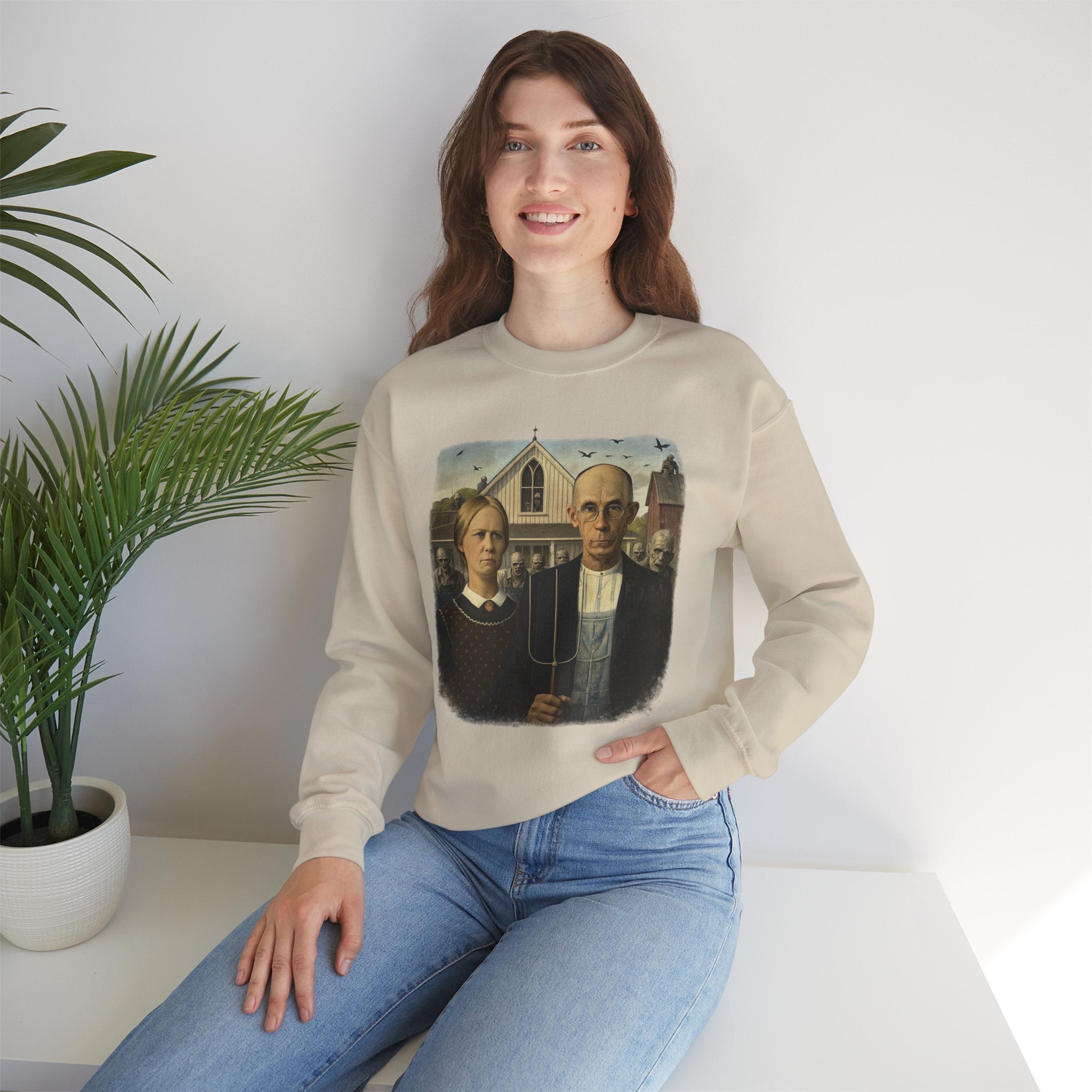 woman wearing cream sweatshirt with a reimagined image of American Gothic by Grant Wood on a white background