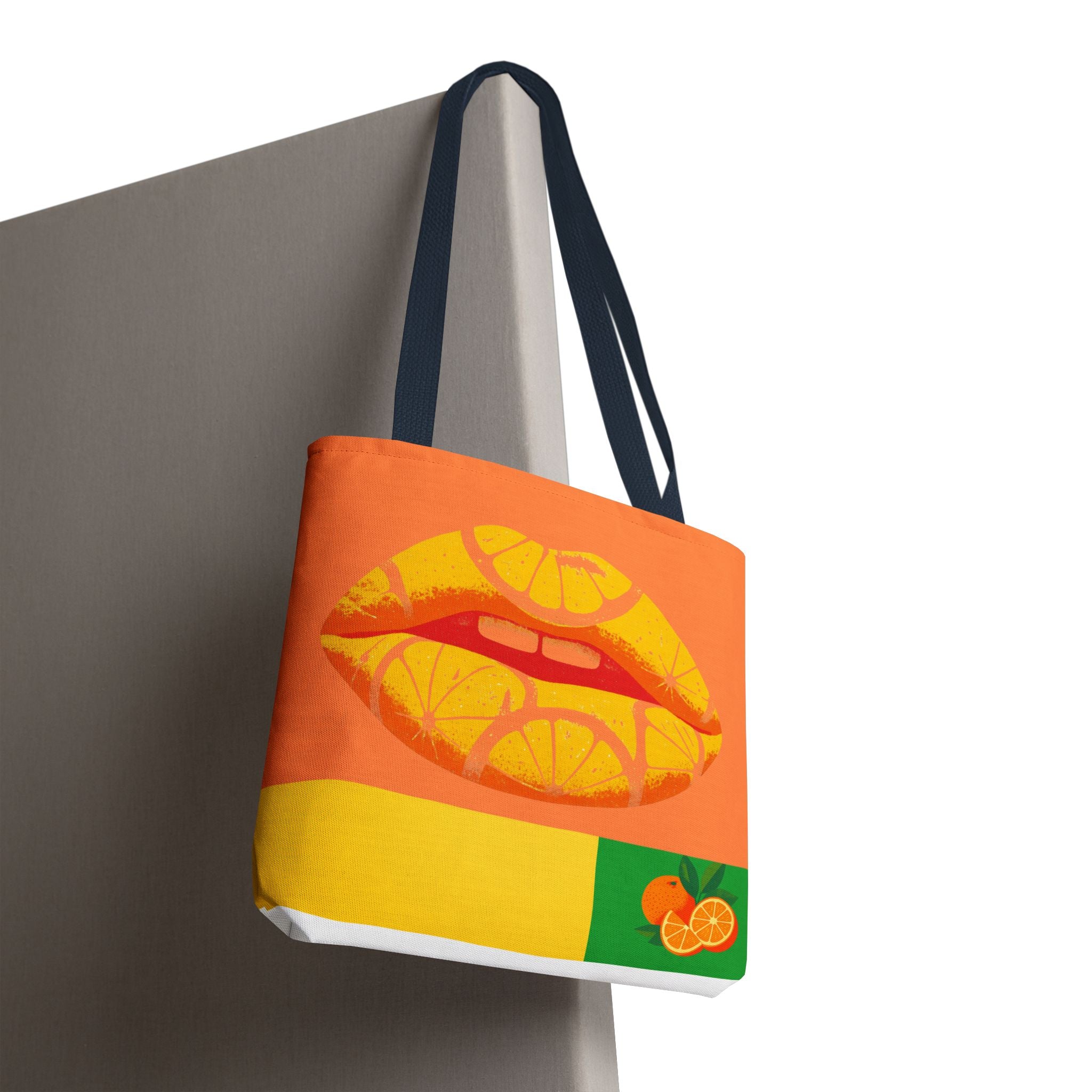 Tote bag with orange and yellow design featuring lips and oranges on a white background
