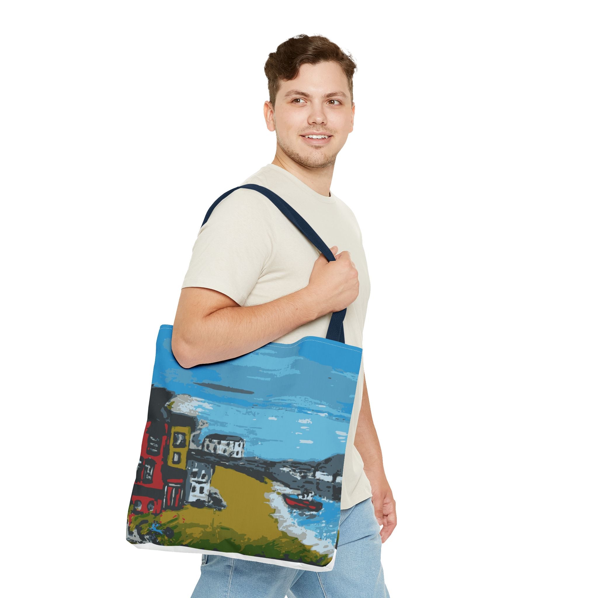 Man holding a tote bag with a colorful design of a coastal scene at Viking Bay, Broadstairs in Kent.