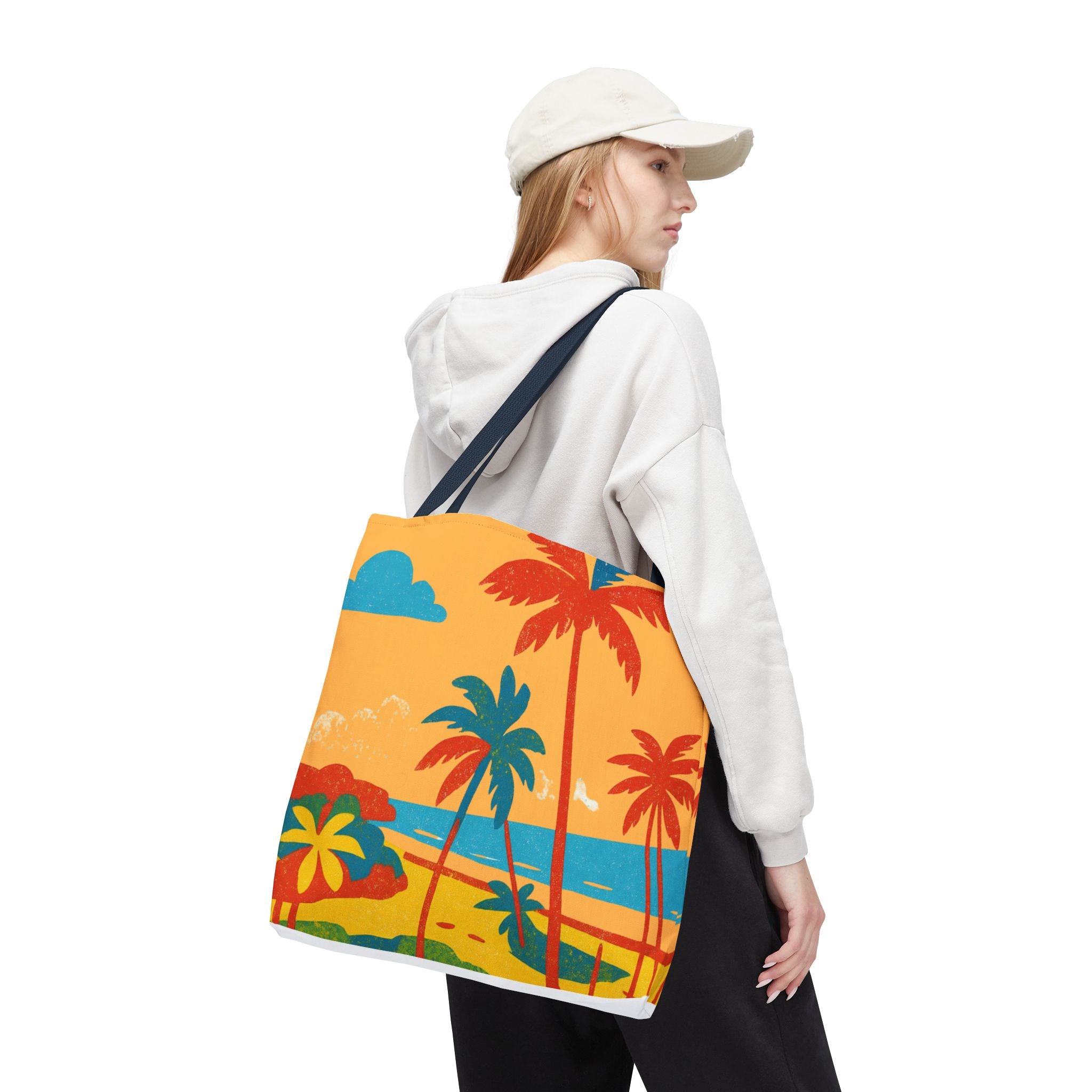 Person wearing a white hoodie and beige cap, carrying a colorful tote bag with palm tree design inspired by St Philip in Barbados.