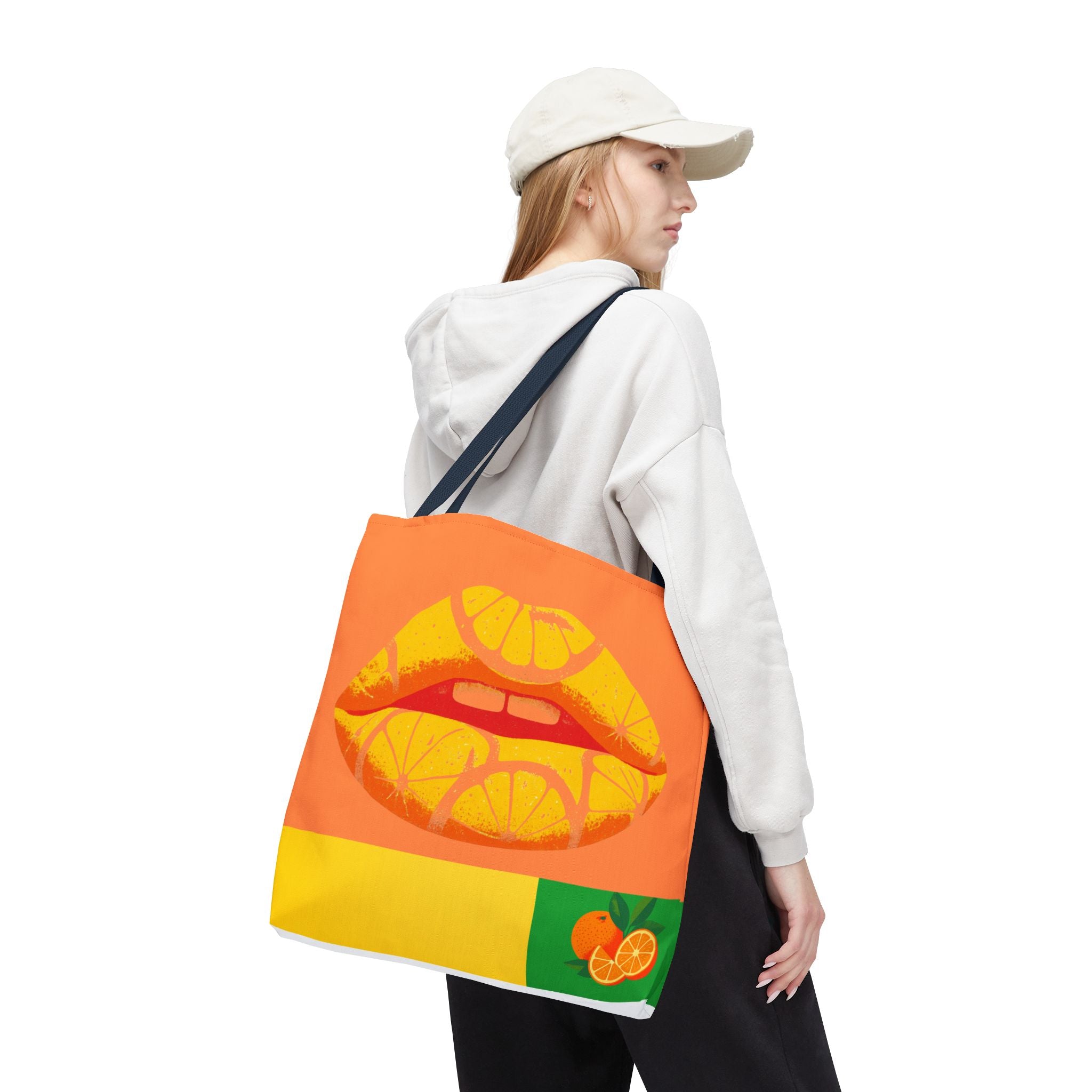 Person holding a tote bag with a colorful lip design and orange slices on a white background