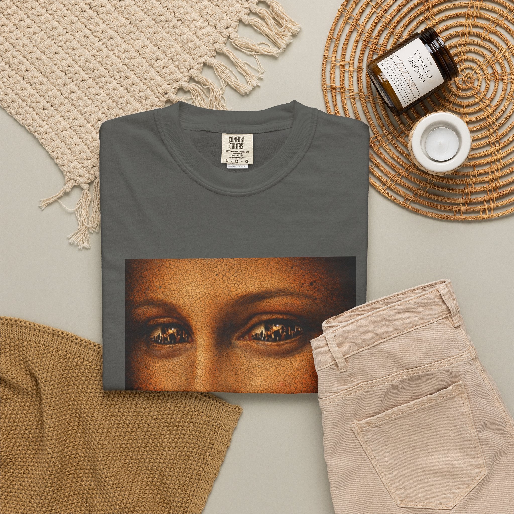 Pepper colour t-shirt showing reimagined image of Da Vinci's Mona Lisa on a background with items such as jeans and candle 