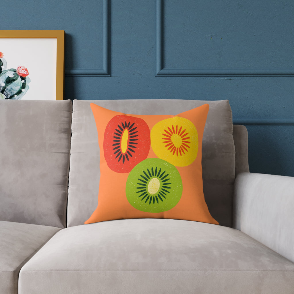 Decorative pillow with kiwi fruit design on a gray sofa against a blue wall.