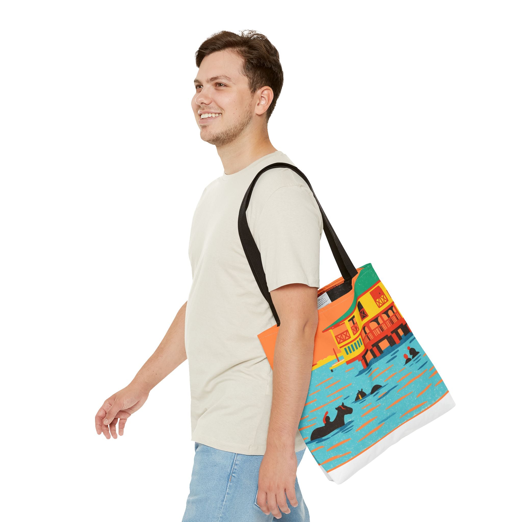Man carrying a colorful tote bag with a design of horses swimming in the sea at Pebbles Beach, Barbados on a white background