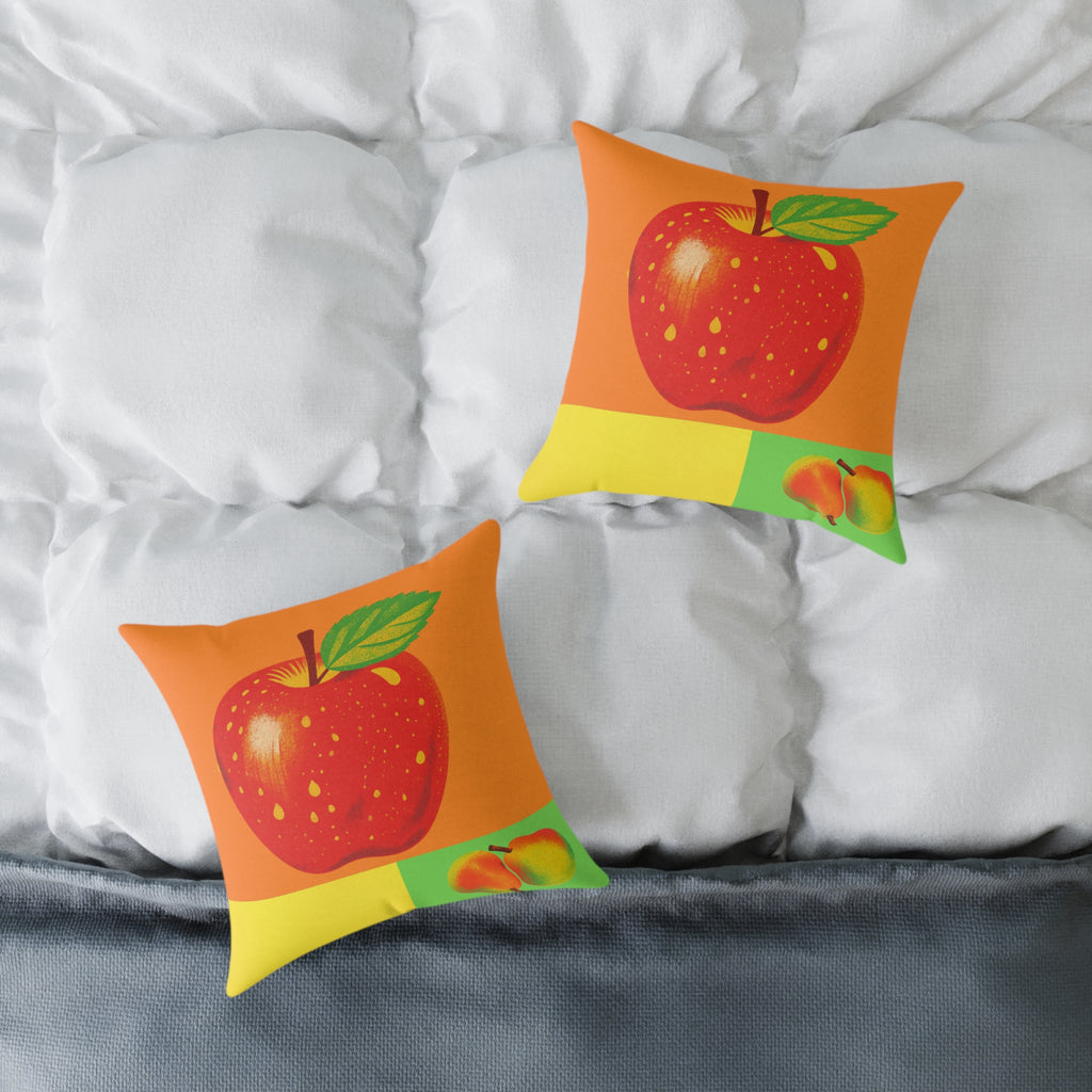 Two decorative pillows with apple designs on a bed