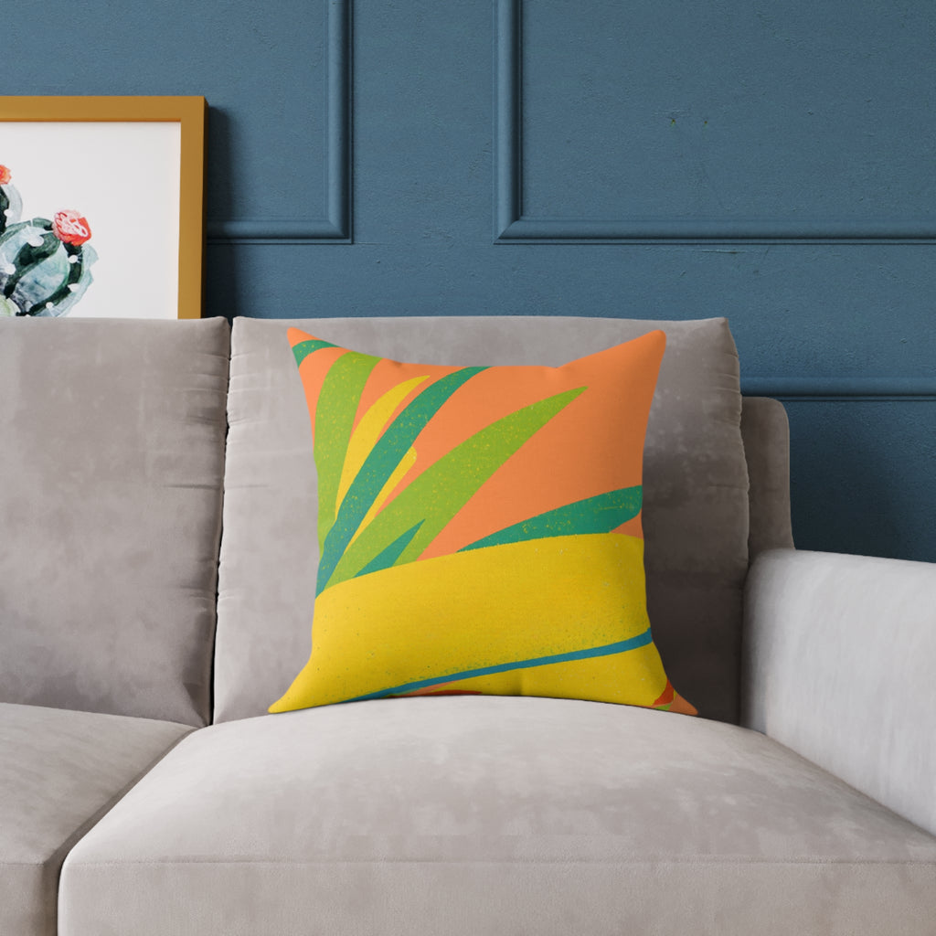 Tropical leaf risograph type print on a cushion on a grey sofa on a blue background.