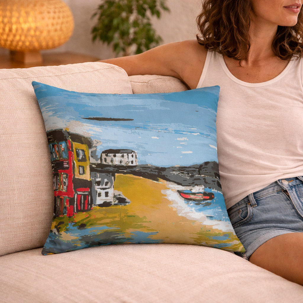 Woman sitting on a couch with a decorative pillow featuring a colorful coastal scene based on viking bay, broadstairs, kent.
