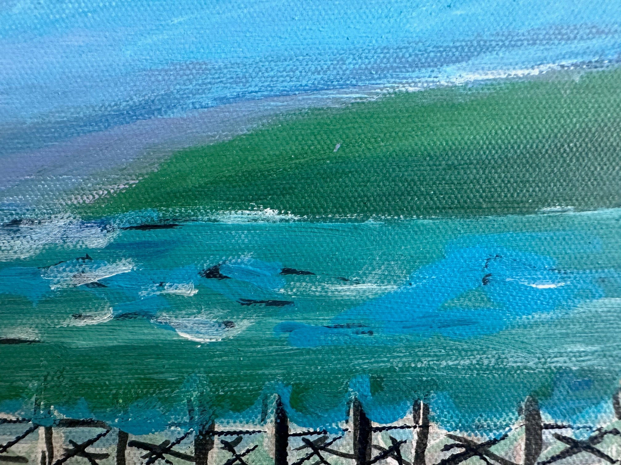 Close-up of a painting of a landscape with green hills and blue sky.